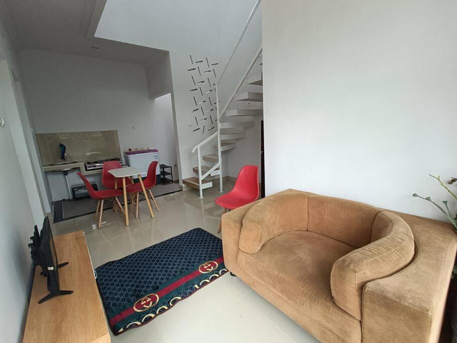 Kebumen的住宿－Rumah Dekat Sawah Pemandangan Pegunungan，带沙发和红色椅子的客厅
