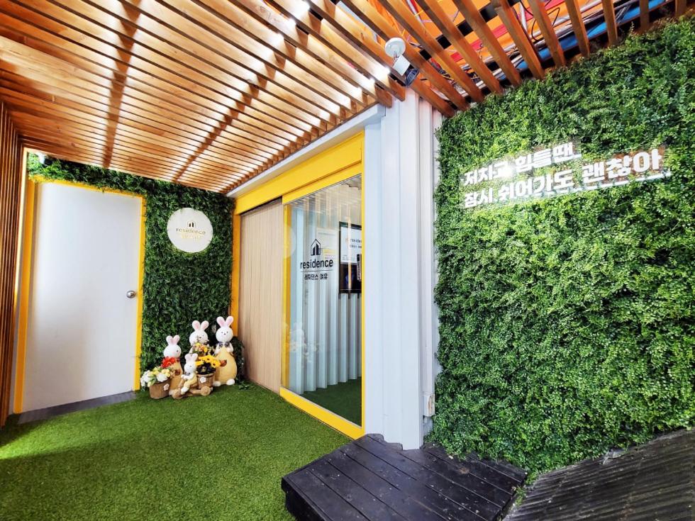 a entrance to a building with a green wall at Residence YeoYu Uijeongbu Station in Uijeongbu