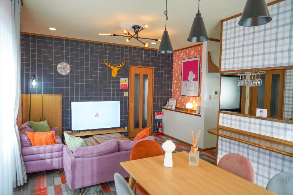 salon z fioletowymi kanapami i stołem w obiekcie Living CUBE Beppu w mieście Beppu