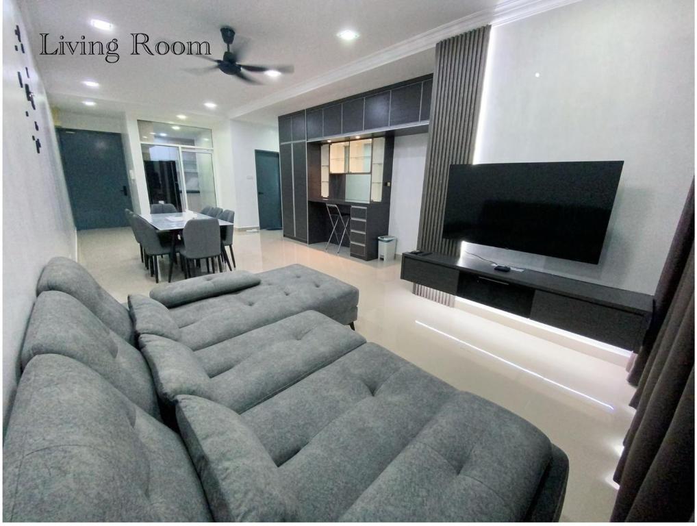 a living room with a large couch and a television at Sandakan Ijm pool view condo in Sandakan
