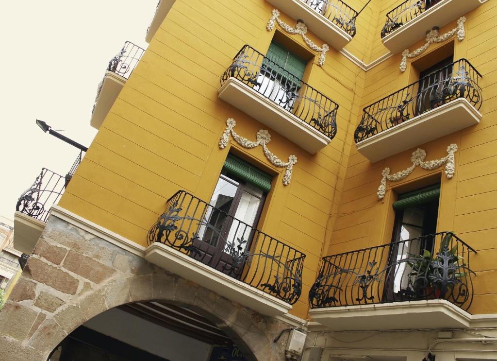 un edificio amarillo con ventanas y balcones en Cal Comabella en Balaguer