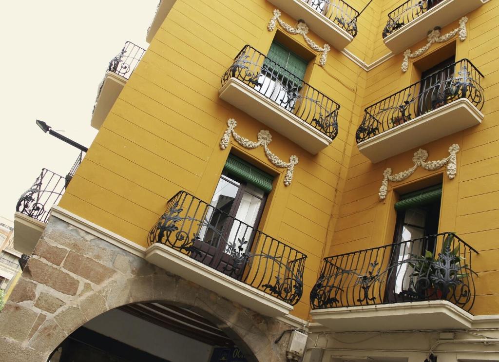 un edificio amarillo con ventanas y balcones en Cal Comabella, en Balaguer