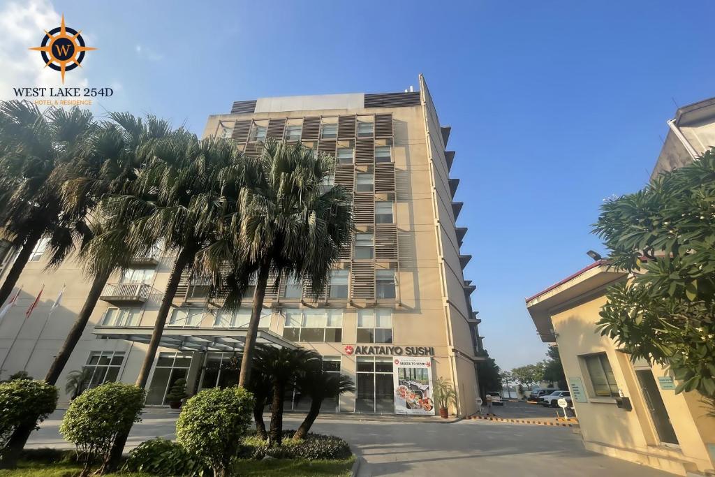 un bâtiment avec des palmiers en face de celui-ci dans l'établissement West Lake 254D Hotel & Residence, à Hanoï
