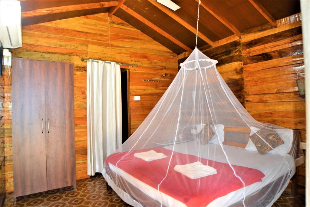 a bedroom with a bed with a mosquito net at Agonda Sun Set in Agonda