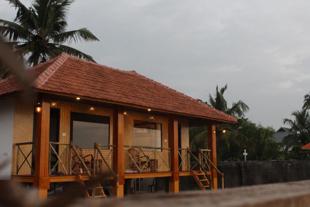 a small house with a balcony on the beach at Marari Sunset Beach Villa in Alleppey
