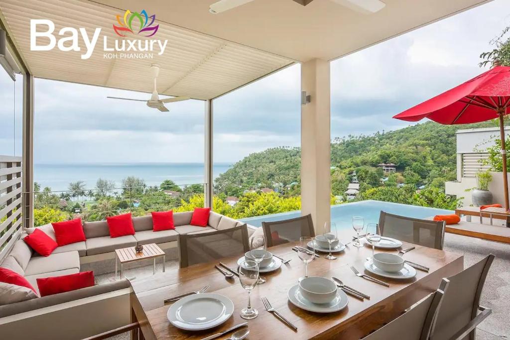 a dining room with a table and a view of the ocean at Luxury Asian Flair Villa in Ko Phangan