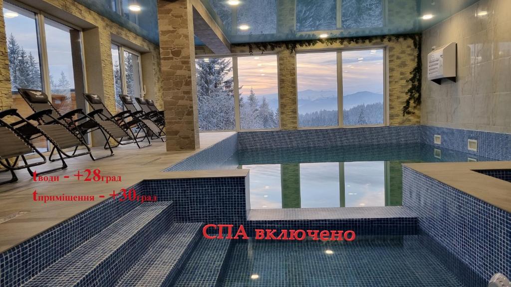 a swimming pool with chairs in a building with a mountain view at SPA hotel Villa Sofia in Yablunytsya