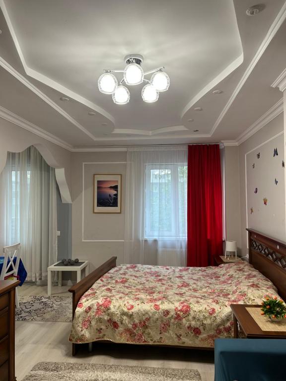 ein Schlafzimmer mit einem Bett und einem roten Vorhang in der Unterkunft Апартаменты в центре Астаны in Astana