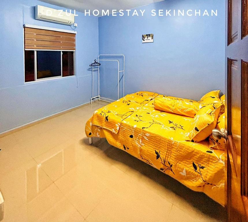 a bedroom with a bed with a yellow comforter at 3-4paxs Sekinchan Dzulhomestasy Padi View Aircon in Kampong Batu Dua Puloh Tiga