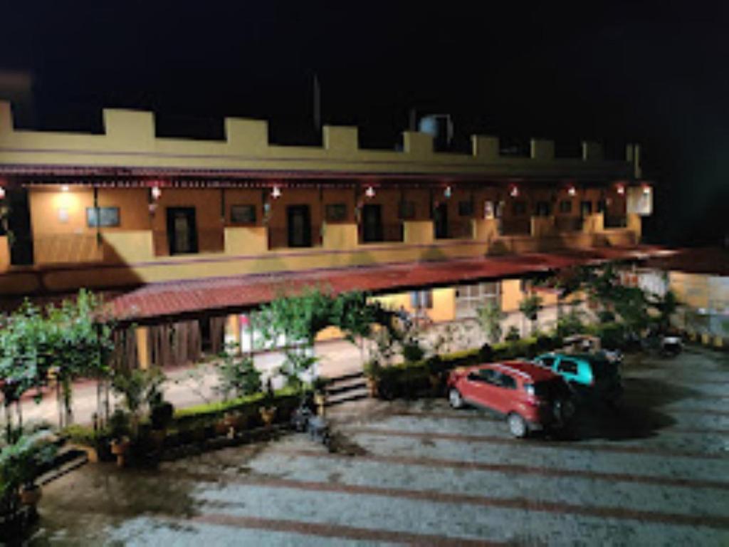 un camión rojo estacionado en un estacionamiento frente a un edificio en Hotel Aaradhya International Jagdalpur, en Jagdalpur