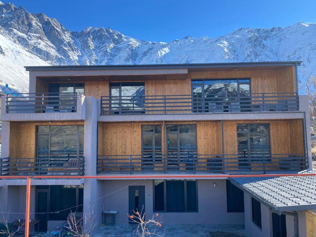 a building with a balcony with mountains in the background at Old district in Stepantsminda