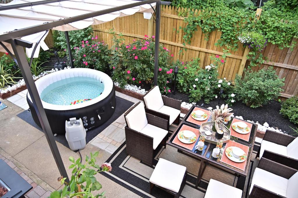 een achtertuin met een hot tub en een tafel en stoelen bij Garden Oasis in Historic Germantown, Philadelphia in Philadelphia