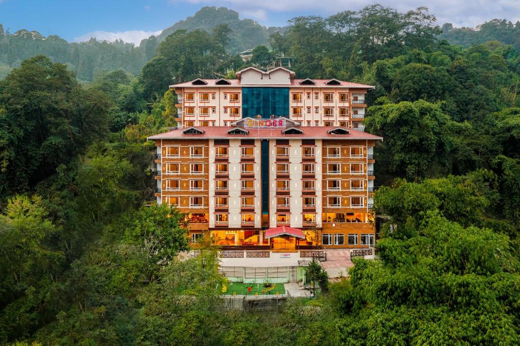 a large building in the middle of a forest at Ginger Gangtok in Gangtok