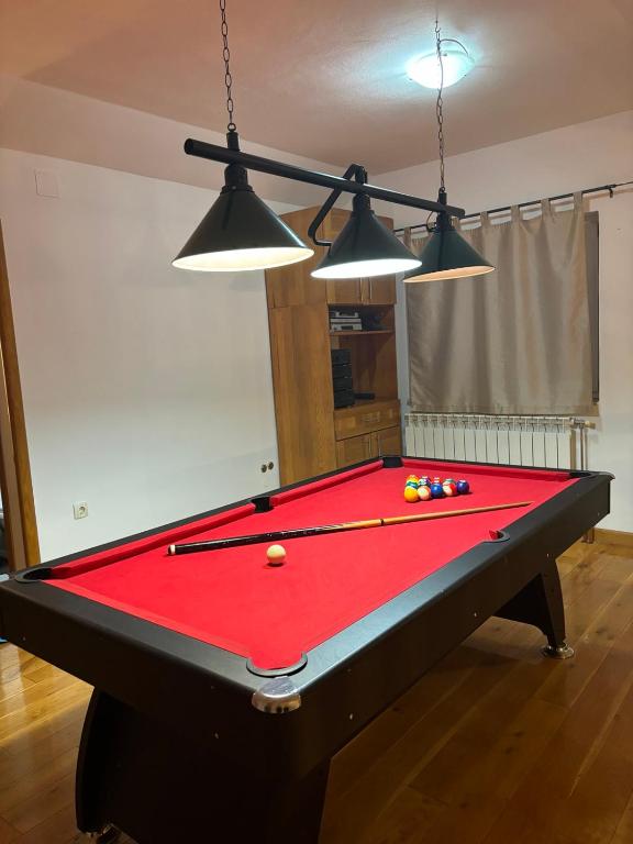 a pool table in a living room with three lights at VILLA M Slatina Banja Luka 