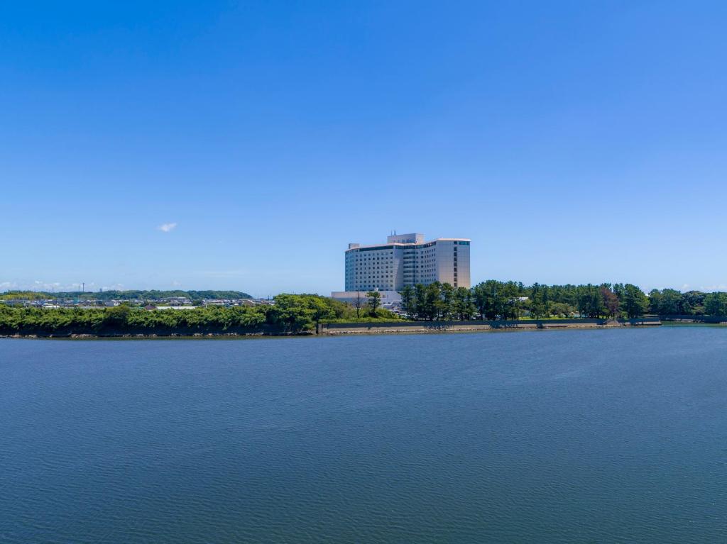 una gran masa de agua con un edificio en el fondo en Grand Mercure Lake Hamana Resort & Spa, en Hamamatsu