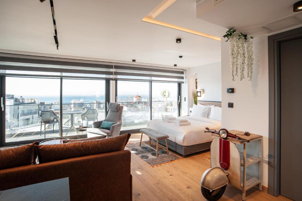 SIGMA Luxury Apartments & Suites في سلانيك: غرفة نوم مع سرير وإطلالة على المحيط