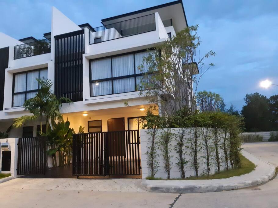 a house with a black fence in front of it at Friendly Townhouse Laguna Park in Thalang