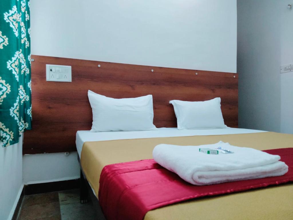 a bedroom with two beds with white pillows at Hotel Royal Green Inn in Chennai