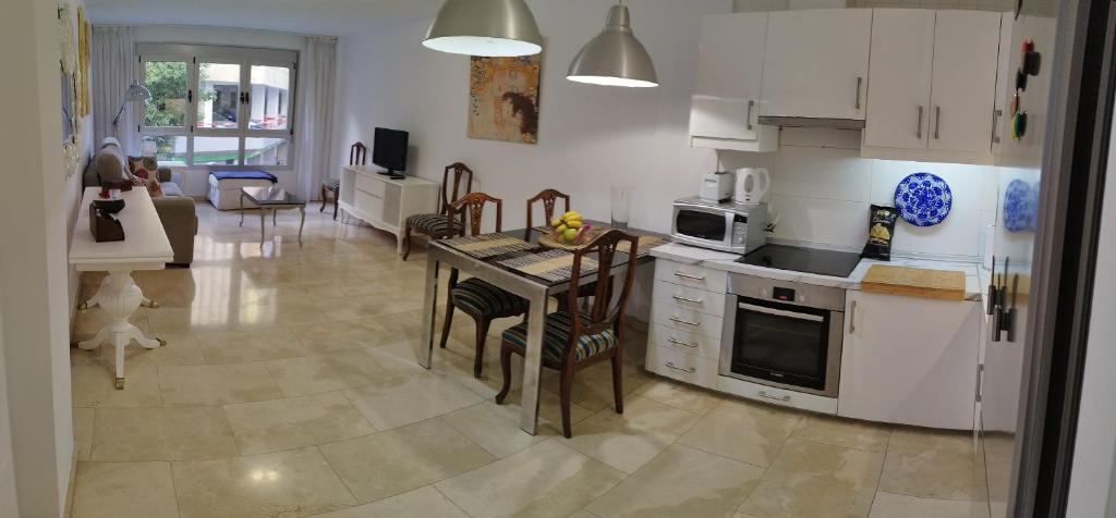 eine Küche und ein Wohnzimmer mit einem Tisch und Geräten in der Unterkunft MAND CANTERAS in Las Palmas de Gran Canaria