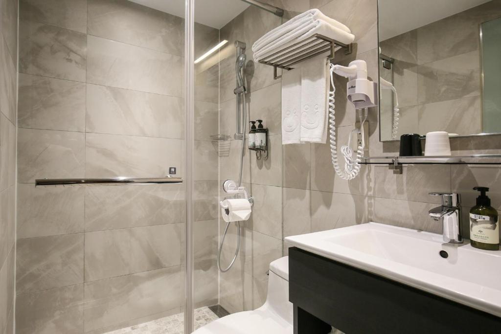 a bathroom with a shower and a toilet and a sink at Cityinn Hotel Taipei Station Branch I in Taipei