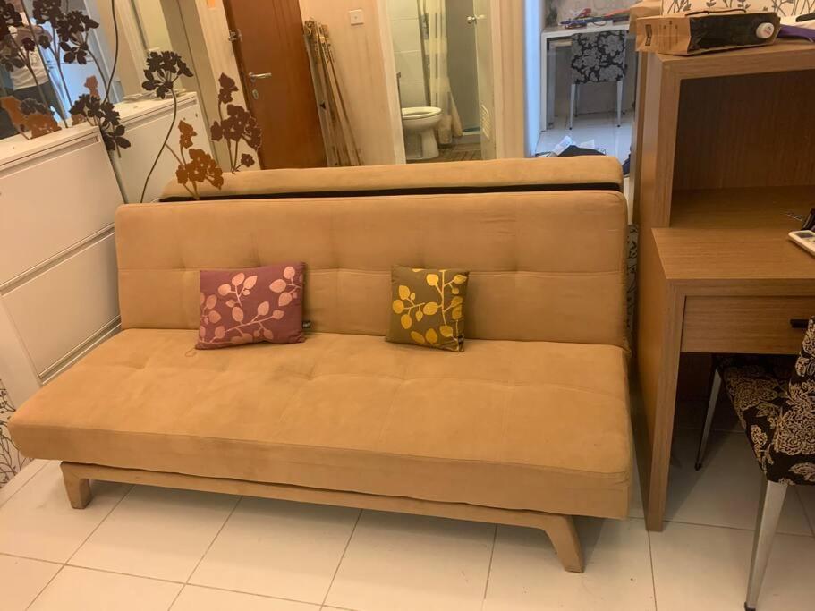 a couch with two pillows on it in a room at Apartmen 1BR di Surabaya timur in Surabaya