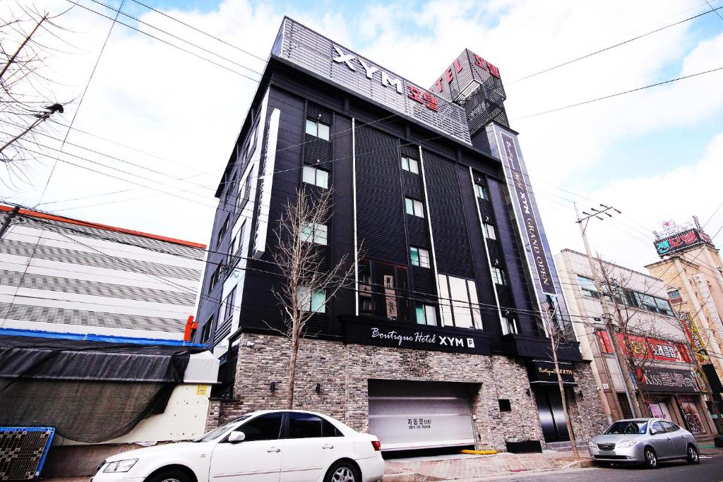 a black building with cars parked in front of it at XYM Hotel Mundeok in Pohang