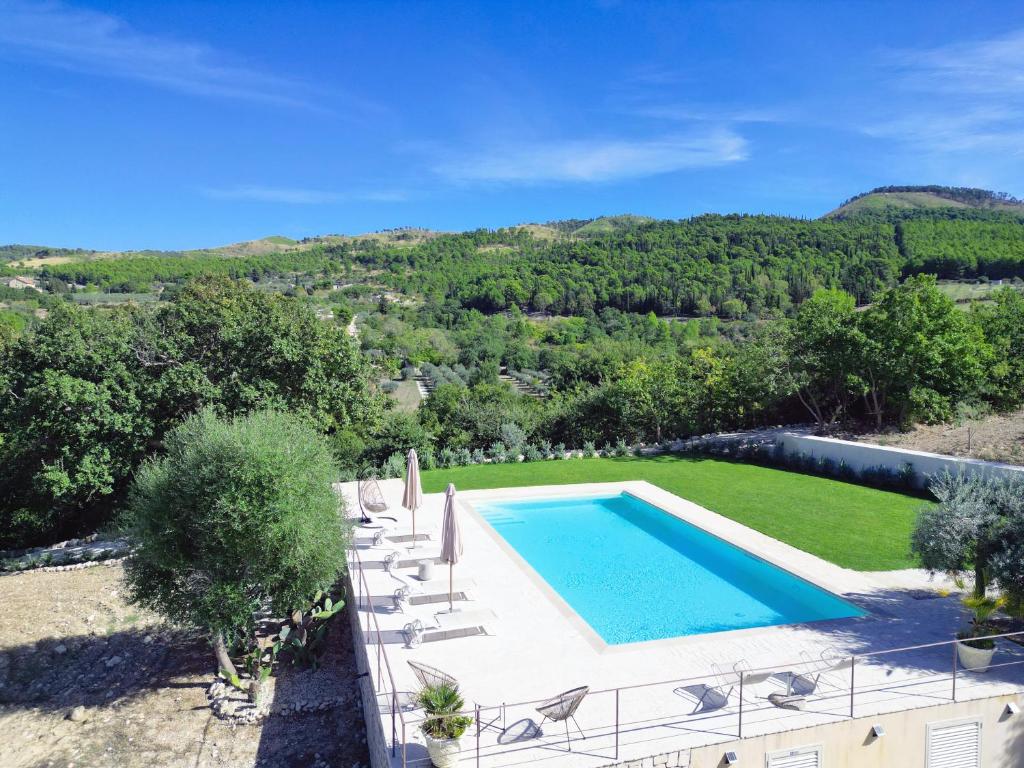 vista esterna su una piscina e su un prato con sedie e piscina di Villa Santa Margherita a Chiaramonte Gulfi