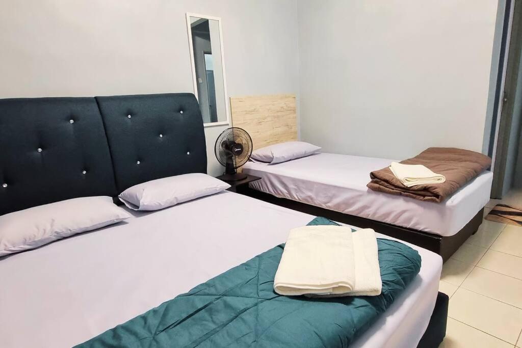 a room with two beds with towels on them at CH Homestay Tanah Rata, Cameron Highlands, Keyless Entry in Tanah Rata