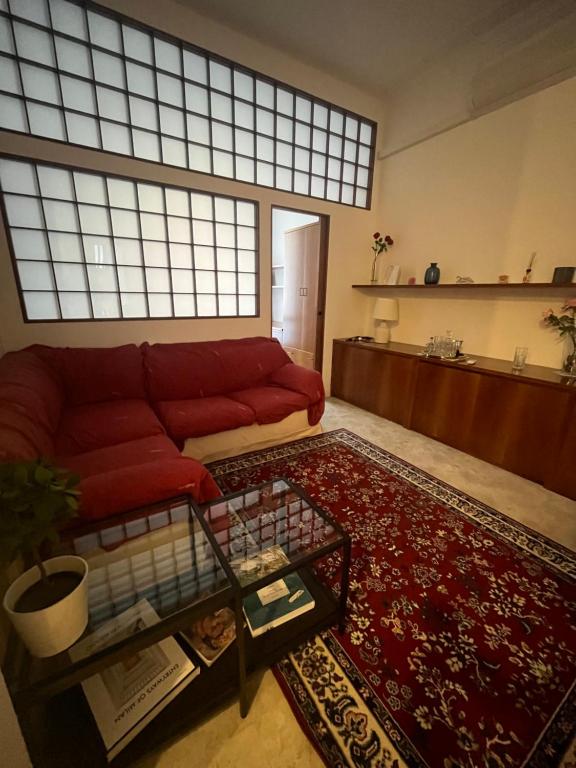 uma sala de estar com um sofá vermelho e um tapete vermelho em Porta Venezia Apartament em Milão