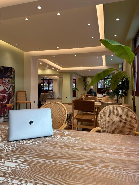 an apple laptop sitting on a table in a restaurant at The Maroon Bottle Luxury Suites in Thessaloniki