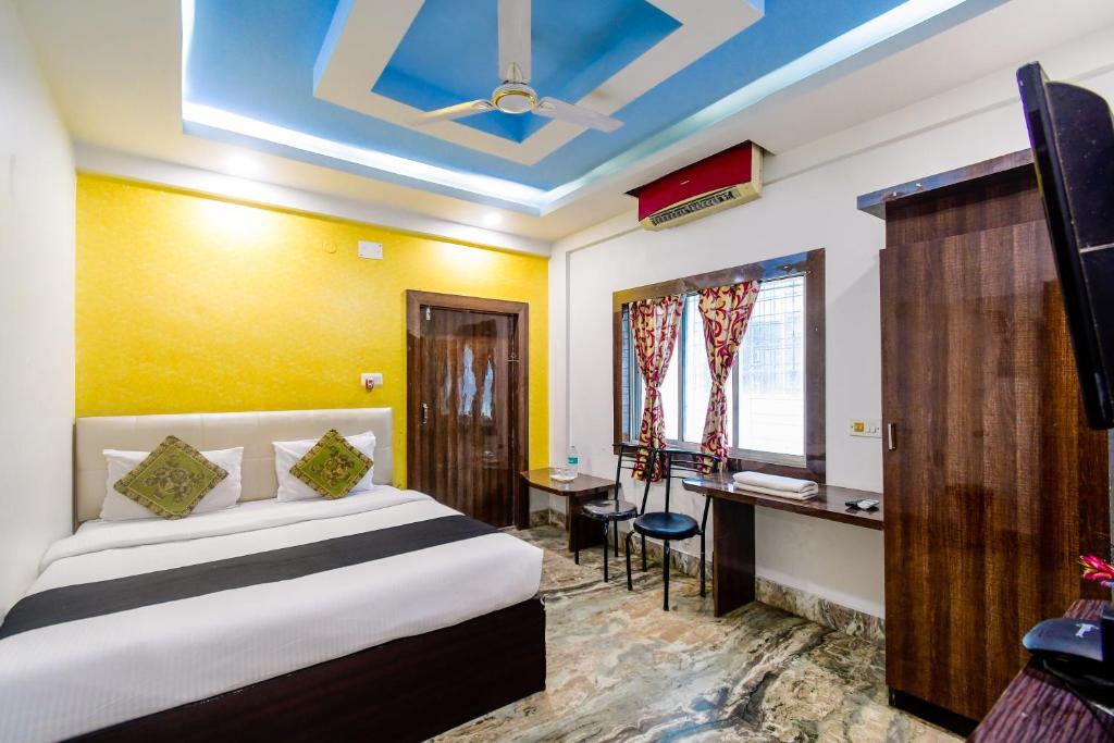 Habitación de hotel con cama y escritorio en Puja Residency, en Thākurdwari
