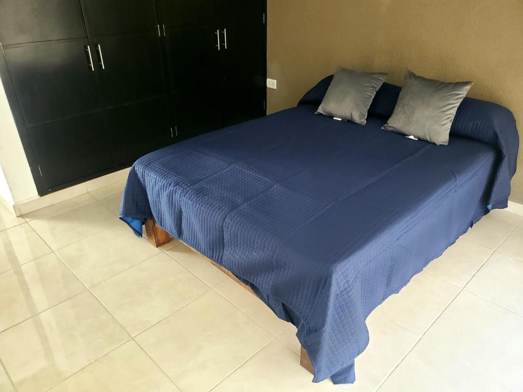 Cama azul en habitación con armarios negros en Casa Santa María en Pénjamo