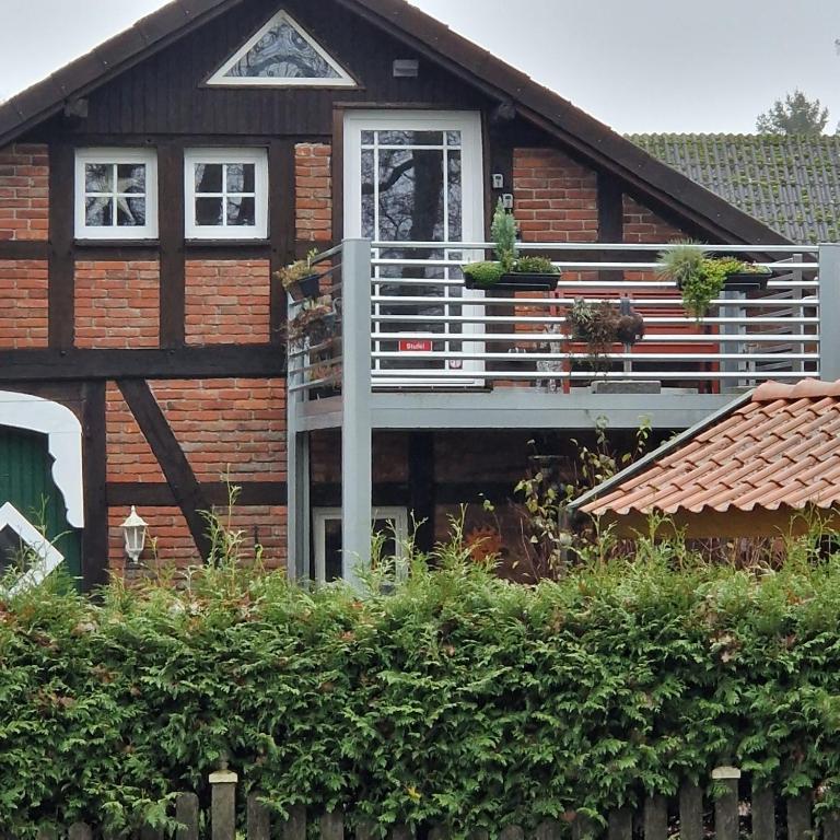 a wooden house with a balcony in front of it at Bei Conny und Bernd in Barnstorf