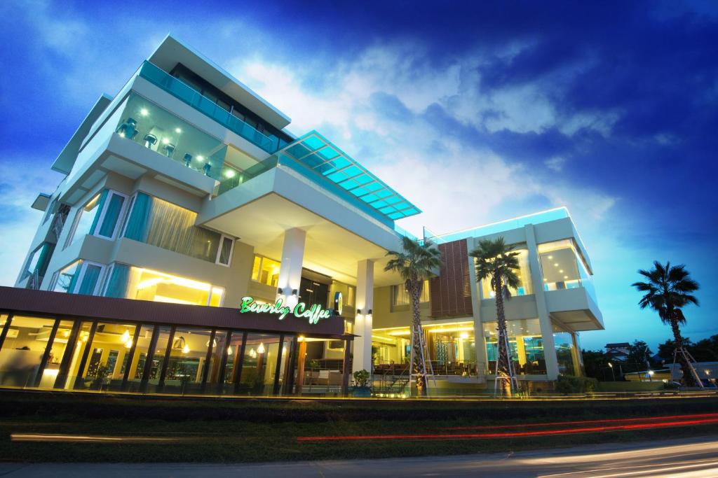 a building with palm trees in front of it at The Beverly Hills Hotel in Nakhon Ratchasima