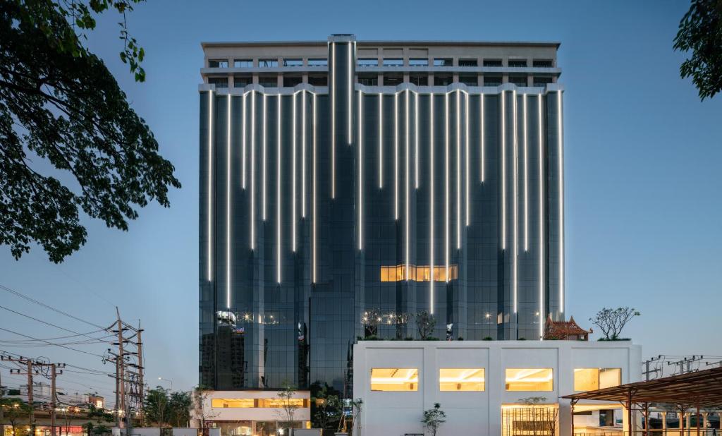 曼谷的住宿－Shenzhen Tower Hotel Thonglor Sukhumvit，一座高大的建筑,旁边是柱子