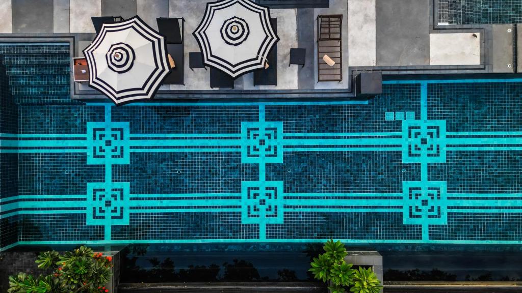 un mural en un edificio con sombrillas. en Mövenpick Hotel Sukhumvit 15 Bangkok, en Bangkok