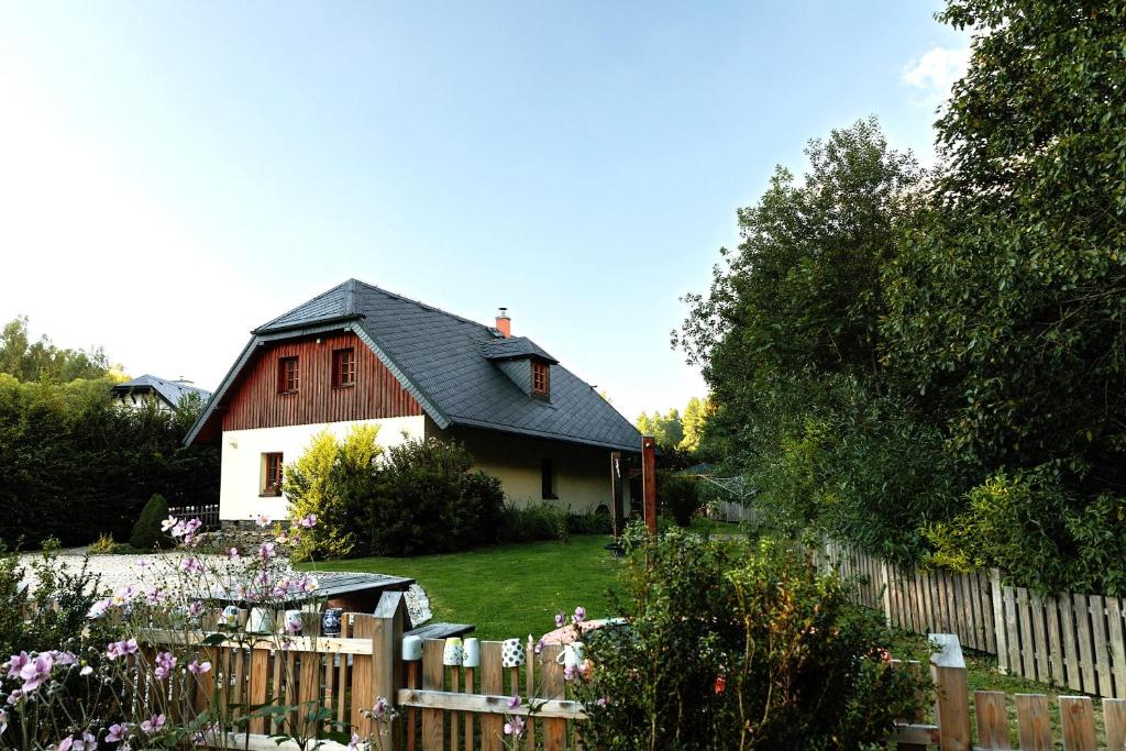 a red and white house with a wooden fence at U potůčku in Malá Morávka