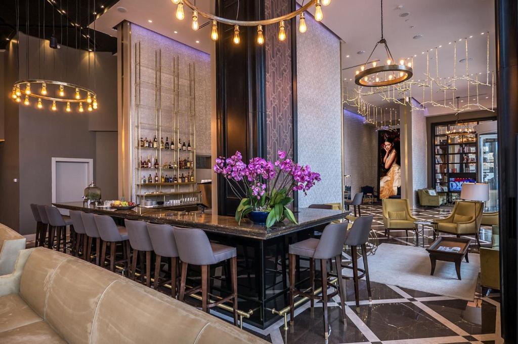 un bar dans un restaurant avec des fleurs violettes sur un comptoir dans l'établissement David Tower Hotel Netanya by Prima Hotels - 16 Plus, à Netanya