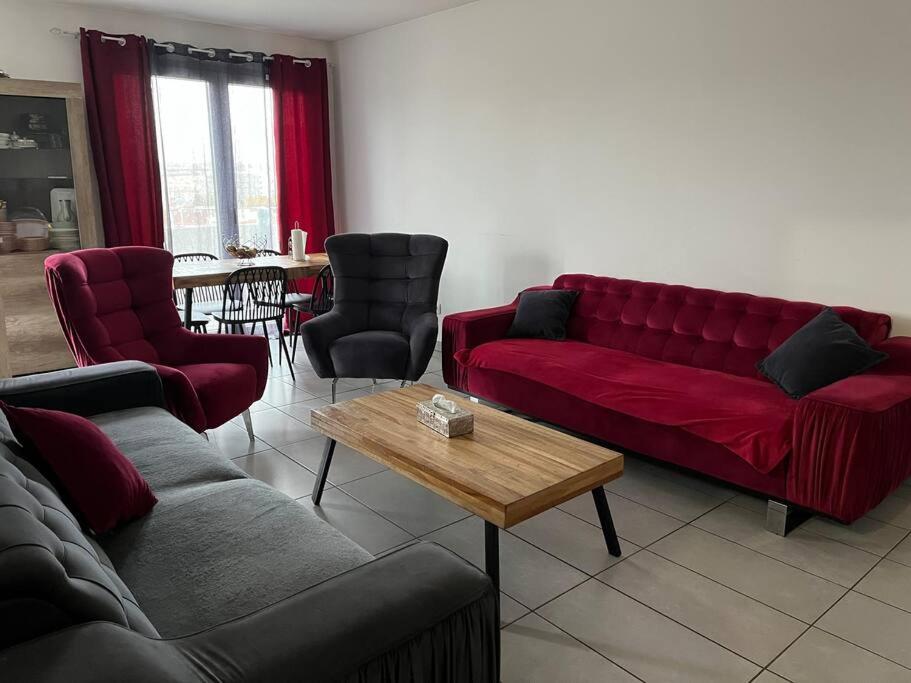 uma sala de estar com um sofá vermelho e uma mesa em Joliette , 4 chambres, wifi em Marselha