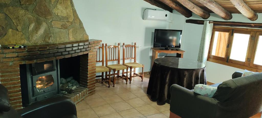 salon z kominkiem i telewizorem w obiekcie Alojamiento Rural El Molino De La Cerrada w mieście Castril