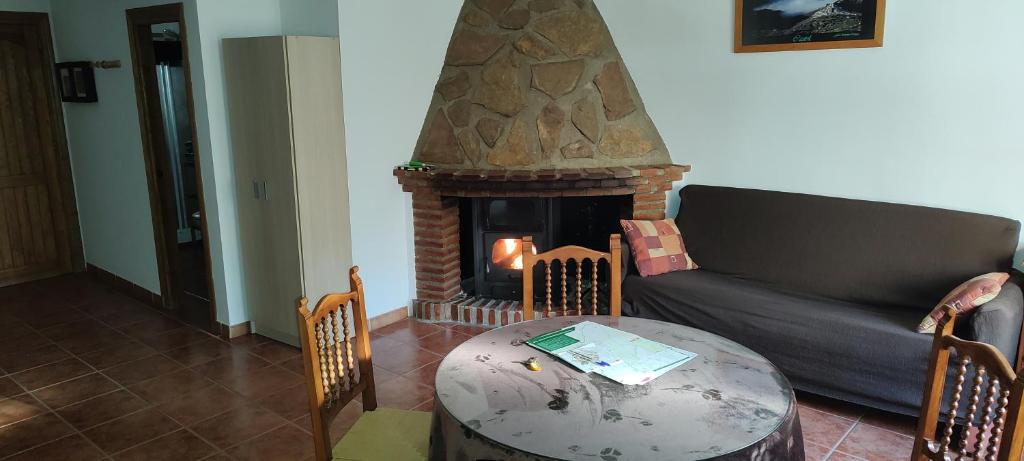 a living room with a table and a fireplace at Alojamiento Rural El Molino De La Cerrada in Castril