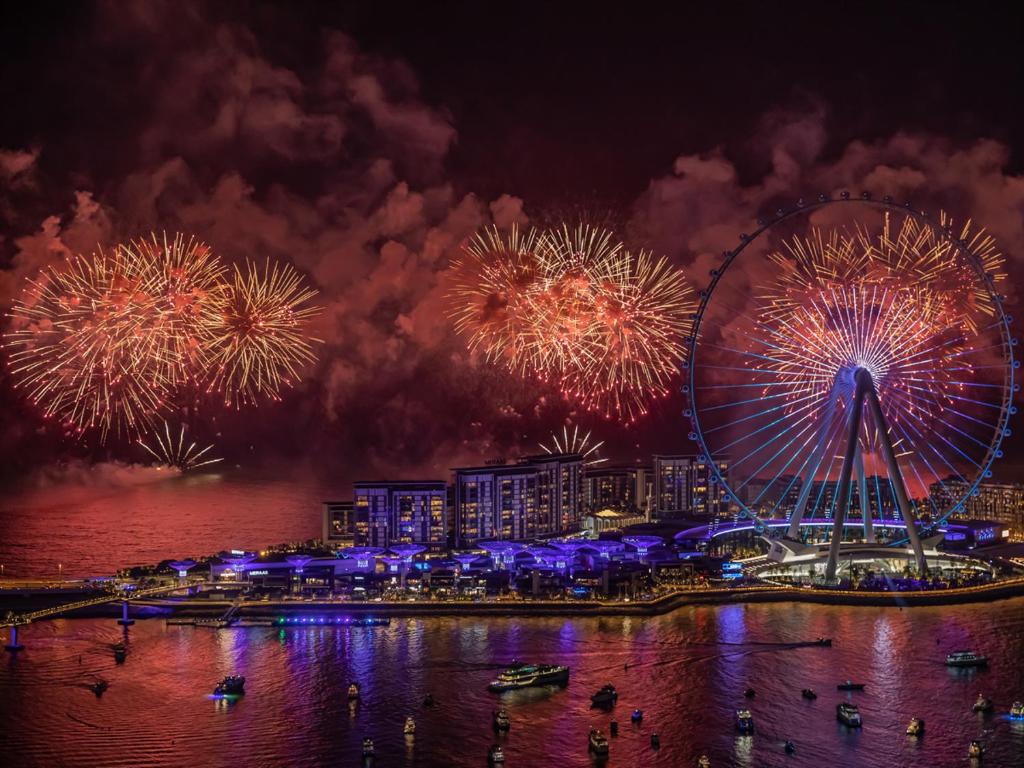 a fireworks display with a ferris wheel and a city at Daniels 3BR with M Address JBR Dubai Eye View in Dubai