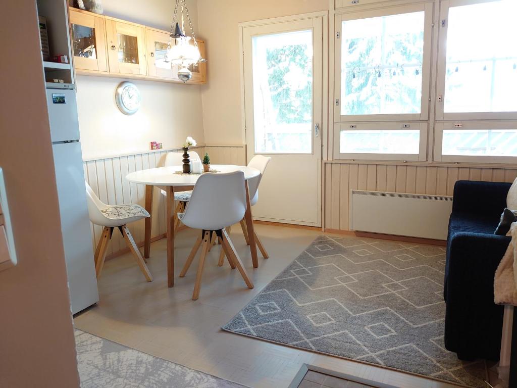 Il comprend une cuisine avec une table et des chaises ainsi que 2 fenêtres. dans l'établissement Rivitalon lomahuoneisto Tahkolla, à Tahkovuori