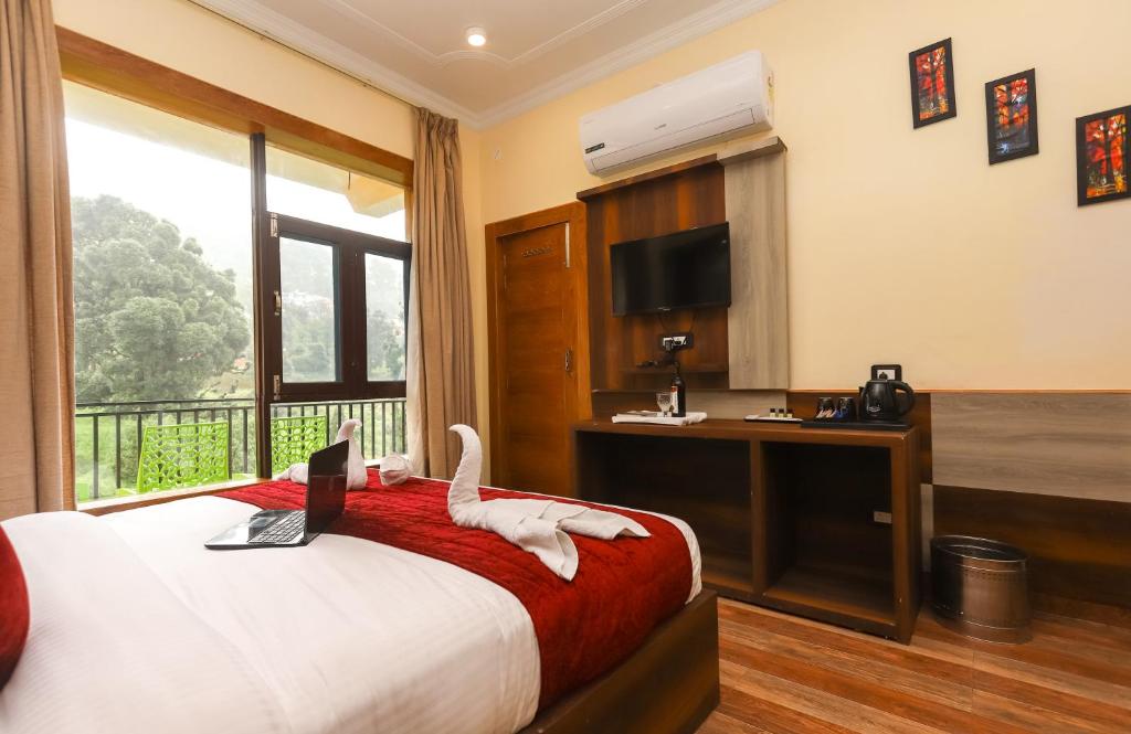 1 dormitorio con 1 cama con ordenador portátil en The Nest with open rooftop cafe Mecleodganj, en Dharamshala