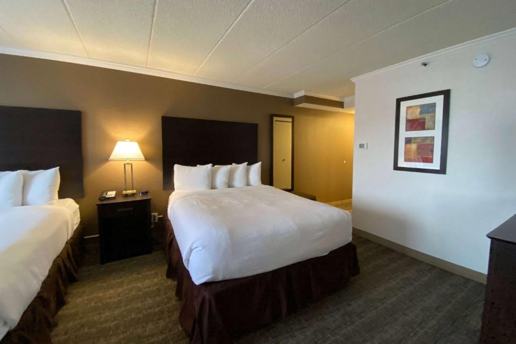 a hotel room with two beds and a lamp at Wyndham Minneapolis South Burnsville in Burnsville