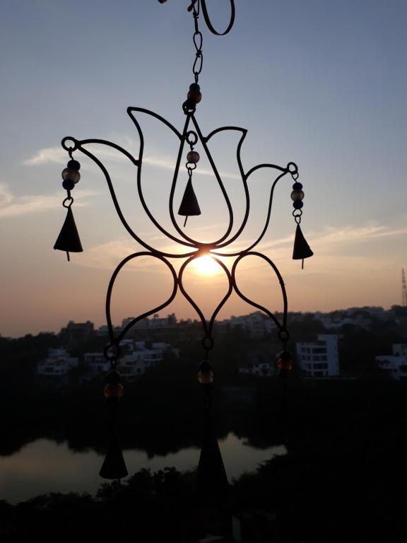 een kroonluchter met de zonsondergang op de achtergrond bij Lotus View Living by Three Peace Soup in Hyderabad