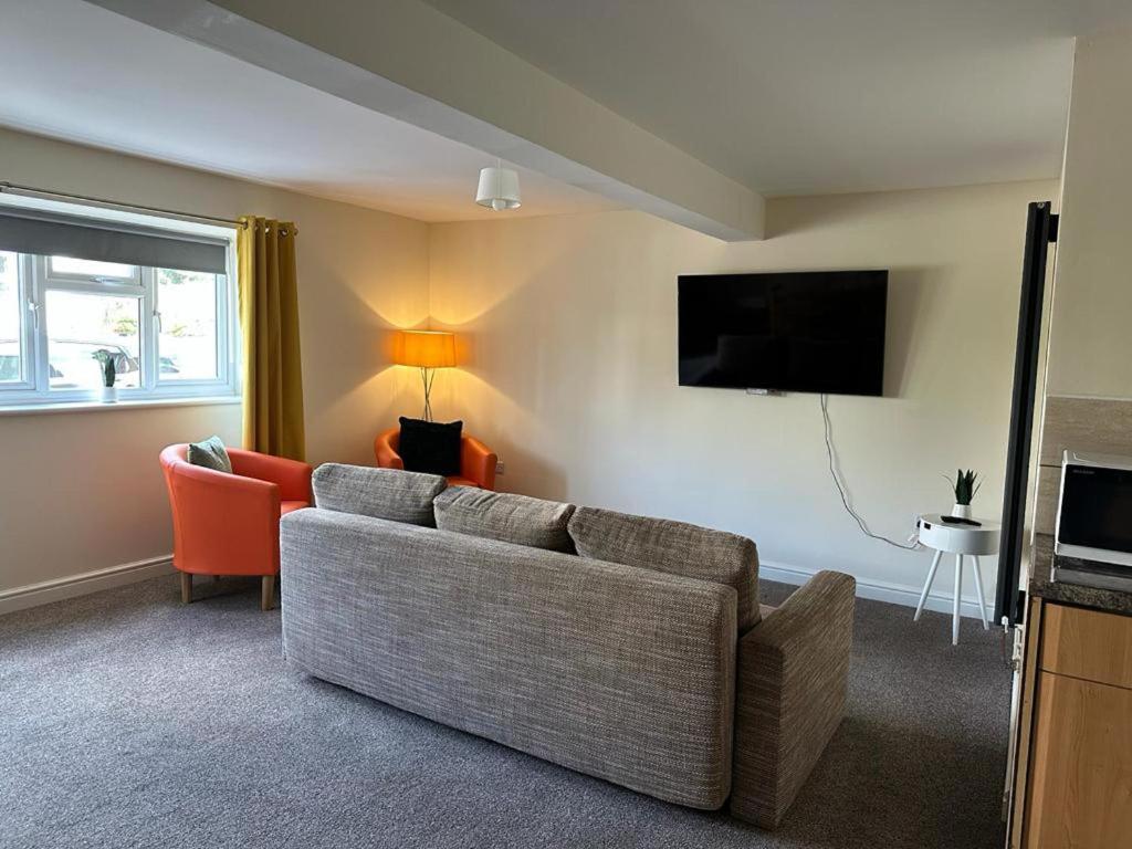 a living room with a couch and a tv at Lovely 2-Bed Apartment in Stroud in Stroud