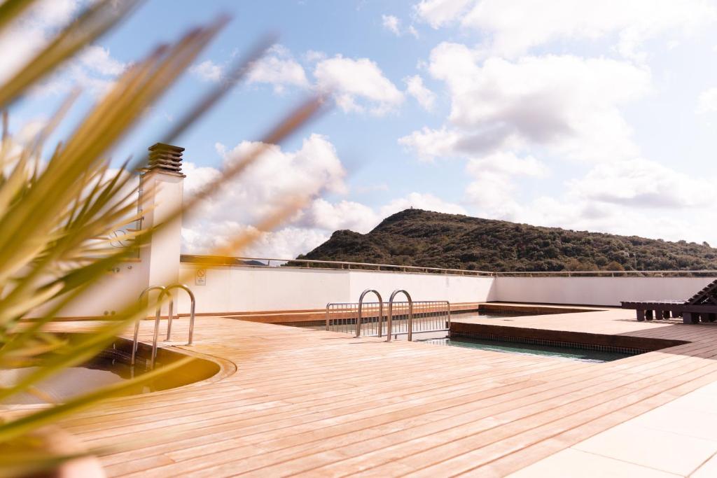 a deck with a view of a mountain in the background at Hotel Loar Ferreries in Ferreries