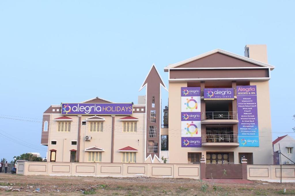 un edificio con un cartel en el costado en Alegria Resort and SPA, Kovalam, en Tirupporūr