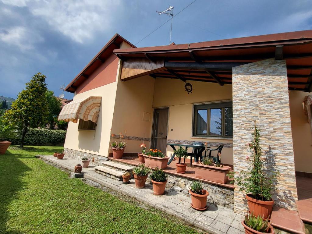 une maison avec des plantes en pot devant elle dans l'établissement The House of Citrus - amazing country house near Viareggio and Lucca, à Stiava